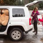 Lynn Logan, of the Alaska Department of Health and Social Services Office of Children Services, is helped load Christmas presents collected by Floyd Dryden Middle School student council members at FDMS on Monday, Dec. 17, 2018. The student organized a school money and toy drive for the OCS program to help needy children. (Michael Penn | Juneau Empire)