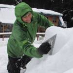 Angela Imboden uses a square tool to smooth out a rough pile of snow that would become a second polar bear in her Juneau yard Thursday, Dec. 27, 2018. (Ben Hohenstatt | Juneau Empire)