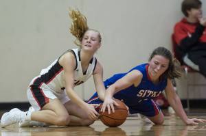 Juneau-Douglas Sadie Tuckwood, left, scrambles for the ball with Sitkas Tawny Smith at the Princess Cruises Capital City Classic at Juneau-Douglas High School on Thursday, Dec. 27, 2018. Juneau-Douglas won 52-25. (Michael Penn | Juneau Empire)