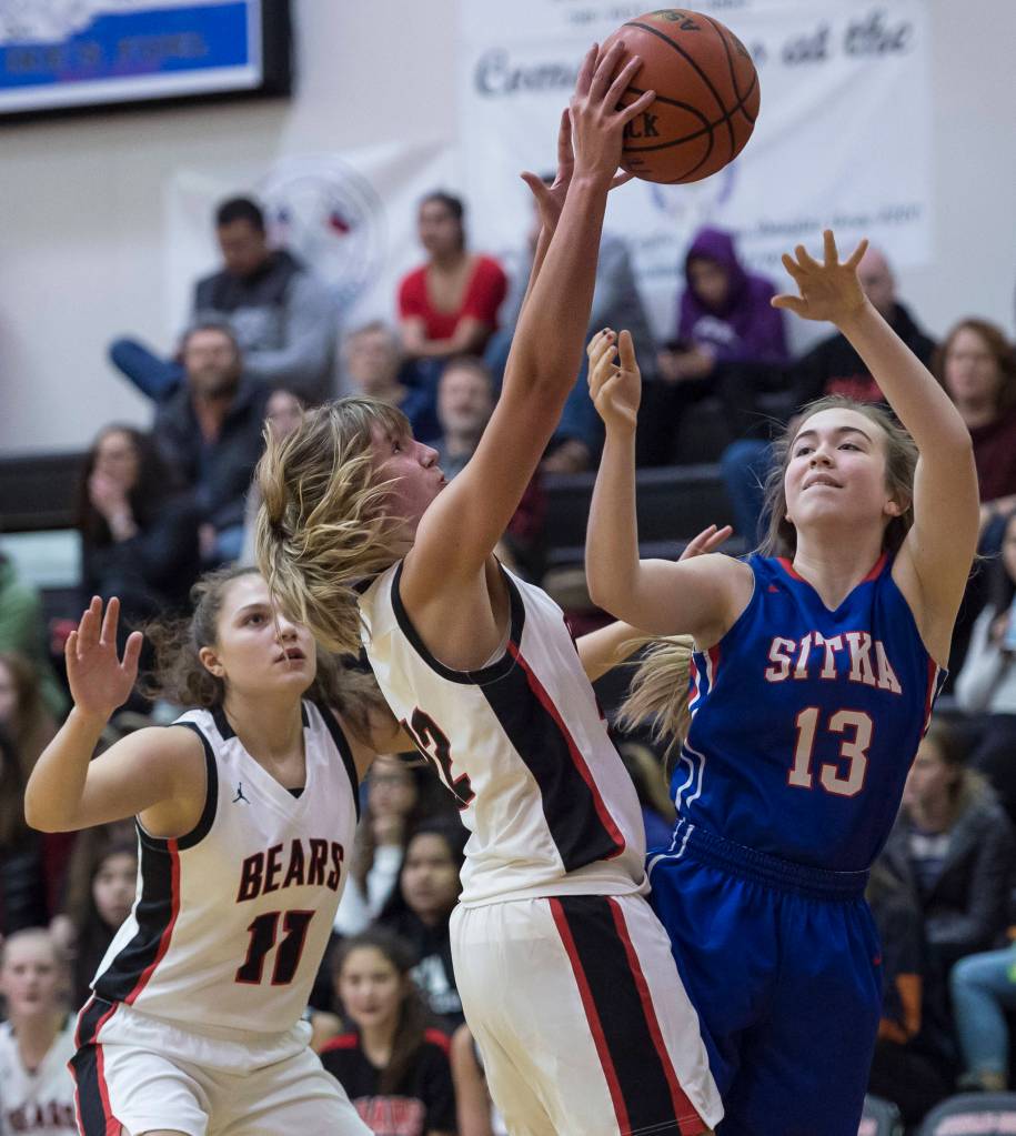 Juneau-Douglas Caitlin Pusich, center, blocks a shot by Sitkas Makenna Smith at the Princess Cruises Capital City Classic at Juneau-Douglas High School on Thursday, Dec. 27, 2018. Juneau-Douglas won 52-25. (Michael Penn | Juneau Empire)