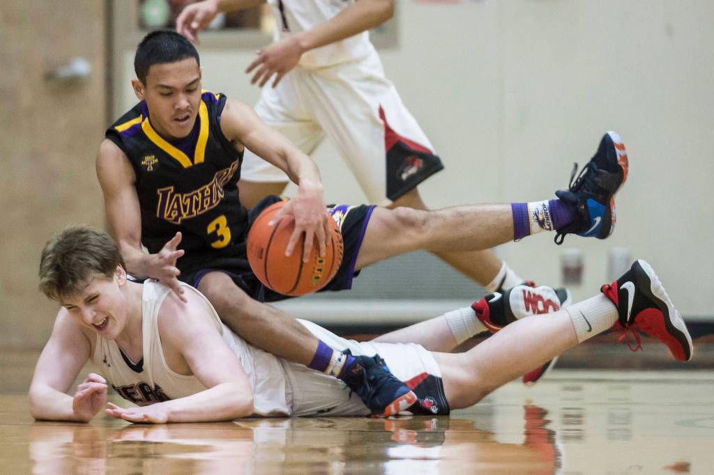 Lathrops Jhon Rones lands on Juneau-Douglas Tad Watson during a loose ball at the Princess Cruises Capital City Classic at Juneau-Douglas High School on Thursday, Dec. 27, 2018. Juneau-Douglas won 69-45. (Michael Penn | Juneau Empire)