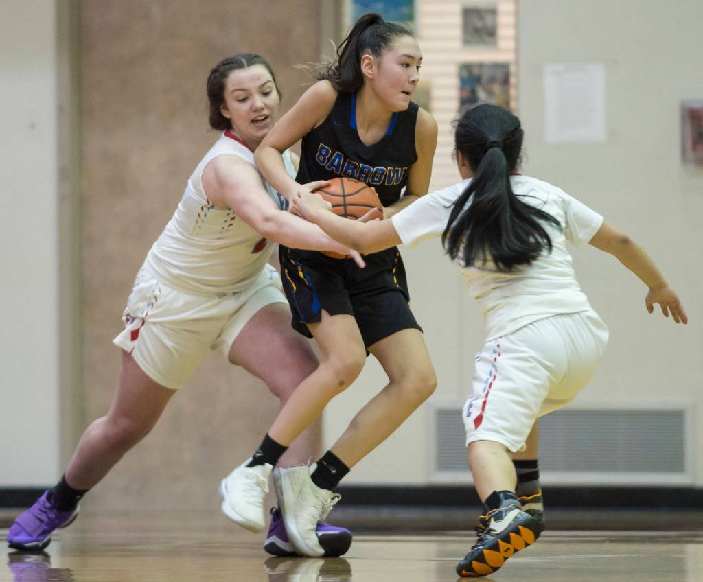 Barrows Jenilee Donovan, center, is pressured by Easts Skye Miller, left, and Angelika Aguirre at the Princess Cruises Capital City Classic at Juneau-Douglas High School on Thursday, Dec. 27, 2018. East won 48-43. (Michael Penn | Juneau Empire)