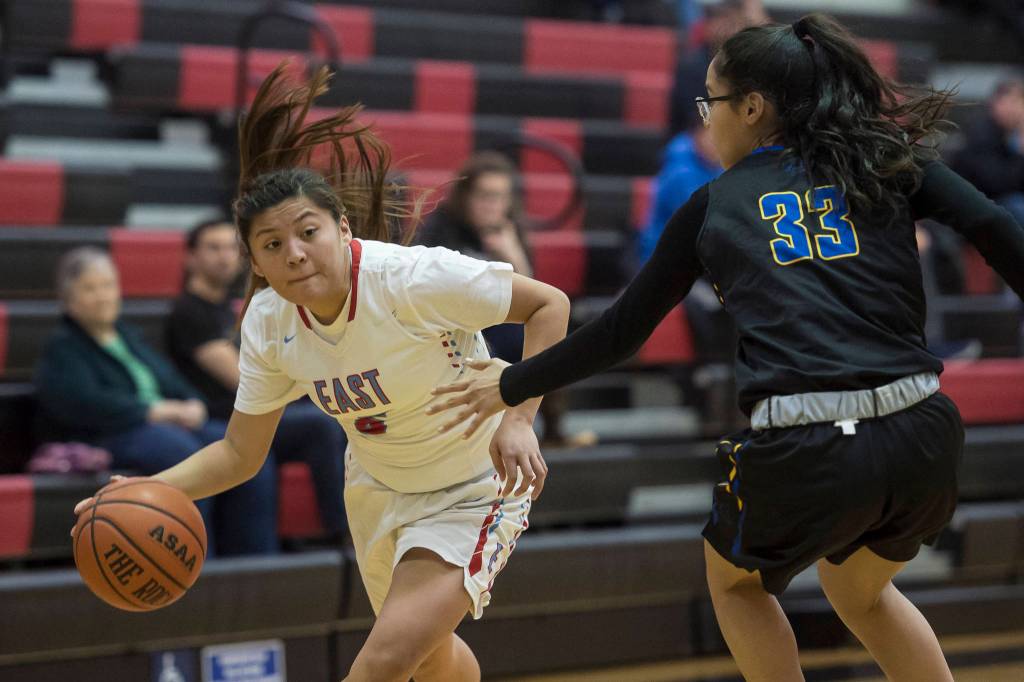 Easts Jayla Jordan, left, drives against Barrows Caitlyn Brower at the Princess Cruises Capital City Classic at Juneau-Douglas High School on Thursday, Dec. 27, 2018. (Michael Penn | Juneau Empire)