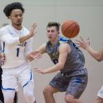 Barrows Mese Unutoa passes to teammate Jefferson Nobleza, right, under pressure from Maine-Endwells Santino Aybar, left, and Joe Costello at the Princess Cruises Capital City Classic at Juneau-Douglas High School on Thursday, Dec. 27, 2018. Barrow won 73-69. (Michael Penn | Juneau Empire)