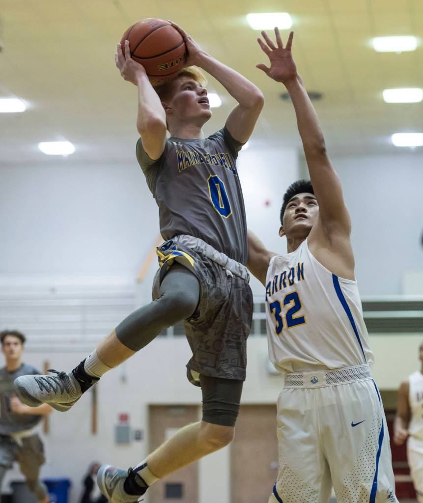 Maine-Endwells Gannon Russell, left, goes up for a shoot against Barrows Jefferson Nobleza at the Princess Cruises Capital City Classic at Juneau-Douglas High School on Thursday, Dec. 27, 2018. Barrow won 73-69. (Michael Penn | Juneau Empire)