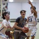 Maine-Endwells Matt Borne, center, drives to the basket between Barrows Brendon Matthews, left, and Isiah Mongoyak at the Princess Cruises Capital City Classic at Juneau-Douglas High School on Thursday, Dec. 27, 2018. Barrow won 73-69. (Michael Penn | Juneau Empire)
