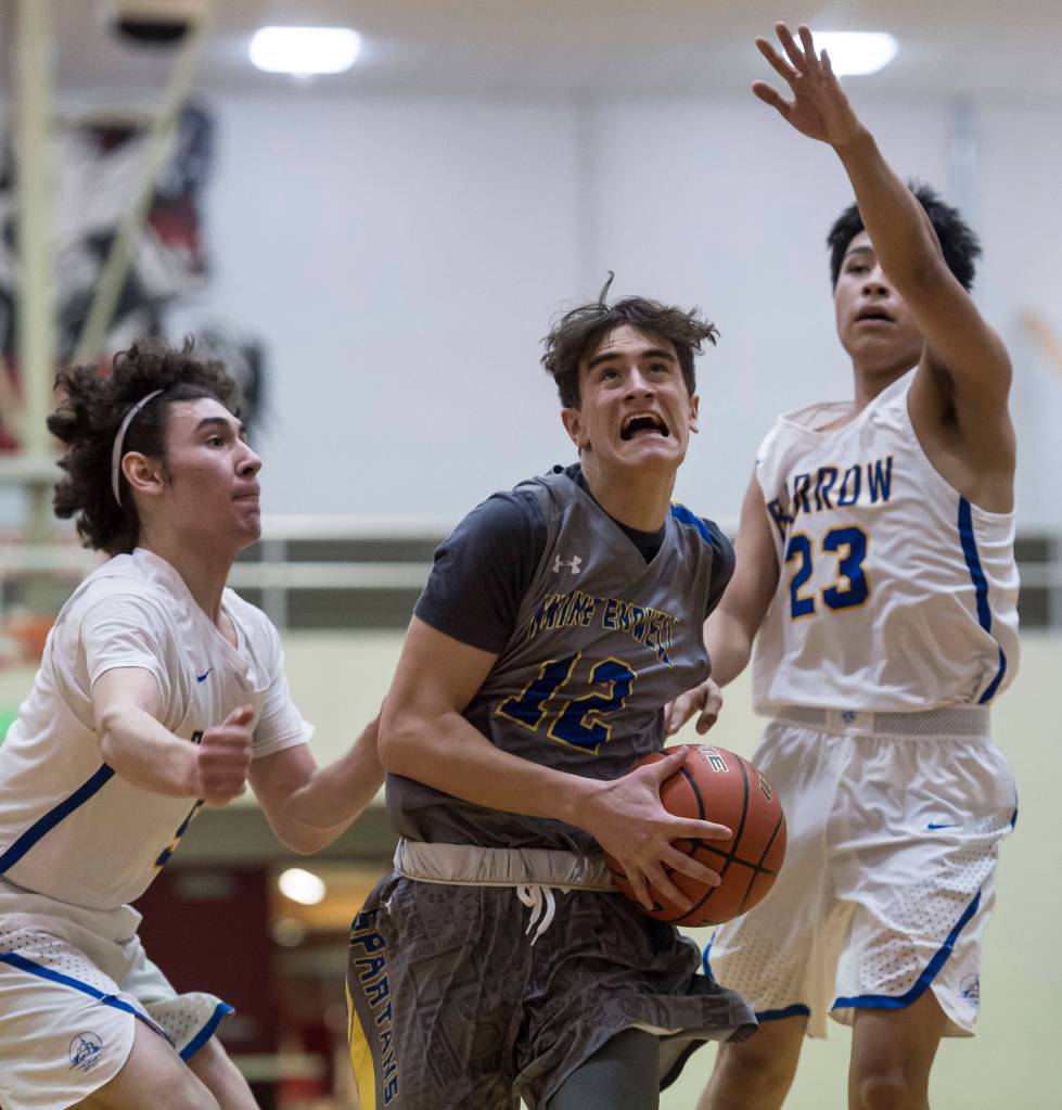 Maine-Endwells Matt Borne, center, drives to the basket between Barrows Brendon Matthews, left, and Isiah Mongoyak at the Princess Cruises Capital City Classic at Juneau-Douglas High School on Thursday, Dec. 27, 2018. Barrow won 73-69. (Michael Penn | Juneau Empire)