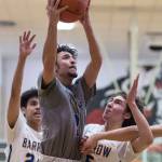 Maine-Endwells Santino Aybar, center, drives to the basket between Barrows Kainoa Texeira, left, and Brendon Matthews at the Princess Cruises Capital City Classic at Juneau-Douglas High School on Thursday, Dec. 27, 2018. Barrow won 73-69. (Michael Penn | Juneau Empire)