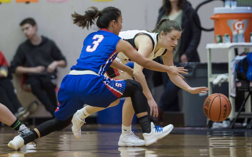 Juneau-Douglas Kiana Potter, right, is pressured by Sitkas Tiffany Elefante at the Princess Cruises Capital City Classic at Juneau-Douglas High School on Thursday, Dec. 27, 2018. Juneau-Douglas won 52-25. (Michael Penn | Juneau Empire)