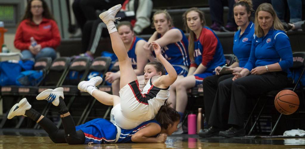 Juneau-Douglas Kiana Potter rolls over Sitkas Tiffany Elefante in a chase for the ball at the Princess Cruises Capital City Classic at Juneau-Douglas High School on Thursday, Dec. 27, 2018. Juneau-Douglas won 52-25. (Michael Penn | Juneau Empire)