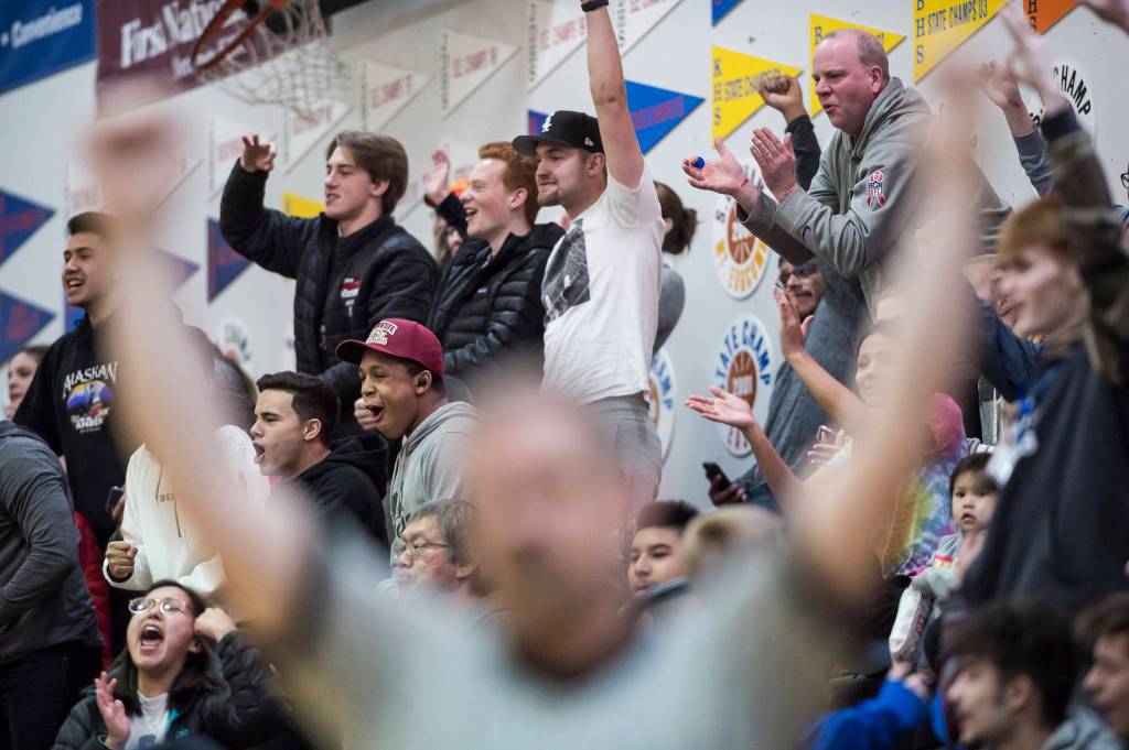 Former Juneau-Douglas players and fans celebrate a three-point shot against Lathrop at the Princess Cruises Capital City Classic at Juneau-Douglas High School on Thursday, Dec. 27, 2018. Juneau-Douglas won 69-45. (Michael Penn | Juneau Empire)