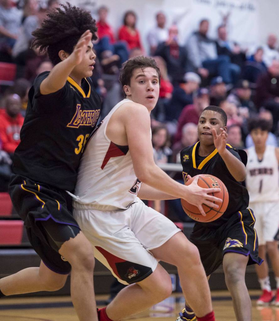 Juneau-Douglas Cooper Kriegmont, center, drives the basket between Lathrops Tyriq Luke, left, and Jakobee Johnson at the Princess Cruises Capital City Classic at Juneau-Douglas High School on Thursday, Dec. 27, 2018. Juneau-Douglas won 69-45. (Michael Penn | Juneau Empire)
