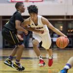 Juneau-Douglas Israel Yadao, right, drives against Lathrops Jakobee Johnson at the Princess Cruises Capital City Classic at Juneau-Douglas High School on Thursday, Dec. 27, 2018. Juneau-Douglas won 69-45. (Michael Penn | Juneau Empire)