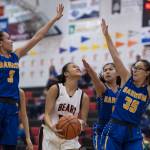 Juneau-Douglas Alyxn Bohulano, center, drives to the basket between Barrows Katelyn Kaleak, left, Lewanne Browerand Sara Wolgemuth, right, at the Princess Cruises Capital City Classic at Juneau-Douglas High School on Friday, Dec. 28, 2018. (Michael Penn | Juneau Empire)