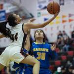 Juneau-Douglas Alyxn Bohulano, left, drives to the basket against Barrows Trinity Manu at the Princess Cruises Capital City Classic at Juneau-Douglas High School on Friday, Dec. 28, 2018. (Michael Penn | Juneau Empire)