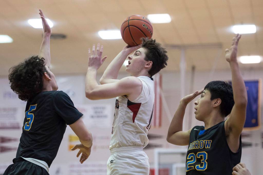 Juneau-Douglas Brock McCormick shoots against Barrows Brendon Matthews, left, and Isiah Mongoyak at the Princess Cruises Capital City Classic at Juneau-Douglas High School on Friday, Dec. 28, 2018. Juneau-Douglas won 68-63. (Michael Penn | Juneau Empire)