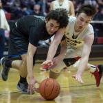 Barrows Brendon Matthews, left, and Juneau-Douglas Brock McCormick dive for a loose ball at the Princess Cruises Capital City Classic at Juneau-Douglas High School on Friday, Dec. 28, 2018. Juneau-Douglas won 68-63. (Michael Penn | Juneau Empire)