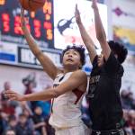 Juneau-Douglas Israel Yadao, left, shoots against Barrows Karl Nobleza at the Princess Cruises Capital City Classic at Juneau-Douglas High School on Friday, Dec. 28, 2018. Juneau-Douglas won 68-63. (Michael Penn | Juneau Empire)