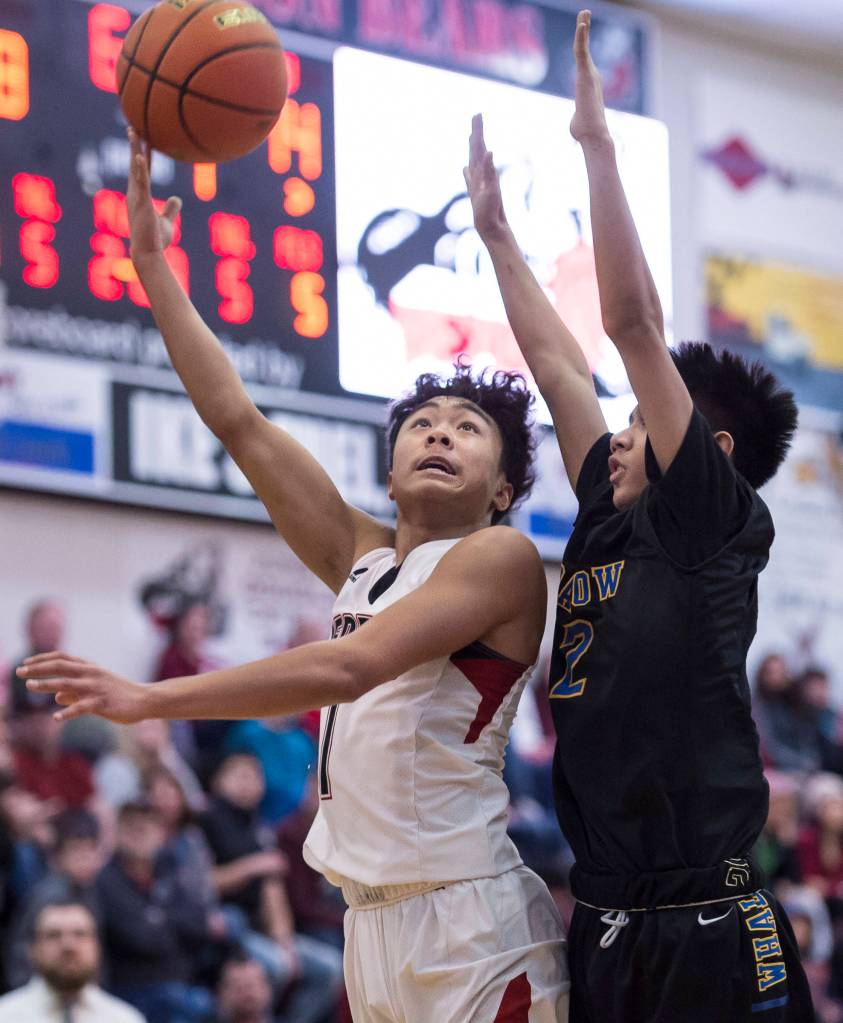 Juneau-Douglas Israel Yadao, left, shoots against Barrows Karl Nobleza at the Princess Cruises Capital City Classic at Juneau-Douglas High School on Friday, Dec. 28, 2018. Juneau-Douglas won 68-63. (Michael Penn | Juneau Empire)