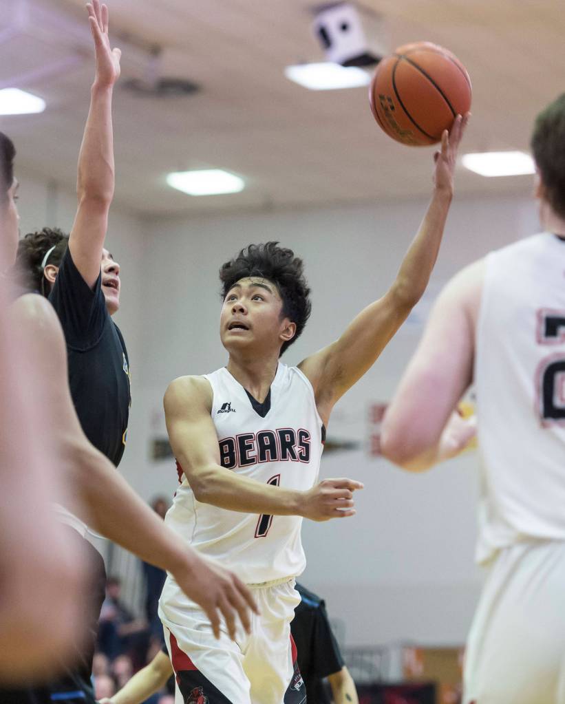 Juneau-Douglas Israel Yadao, left, shoots against Barrows Brendon Matthews at the Princess Cruises Capital City Classic at Juneau-Douglas High School on Friday, Dec. 28, 2018. Juneau-Douglas won 68-63. (Michael Penn | Juneau Empire)