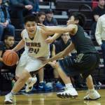 Juneau-Douglas Philip Gonzales, left, drives against Barrows Isiah Mongoyak at the Princess Cruises Capital City Classic at Juneau-Douglas High School on Friday, Dec. 28, 2018. Juneau-Douglas won 68-63. (Michael Penn | Juneau Empire)