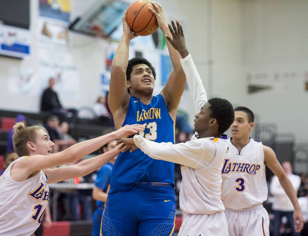 Barrows Anthony Fruean, center, goes up for a shot against Lathrops Jayce Johnson, left, and Mekhi Briggman at the Princess Cruises Capital City Classic at Juneau-Douglas High School on Saturday, Dec. 29, 2018. Barrow won 76-68. (Michael Penn | Juneau Empire)