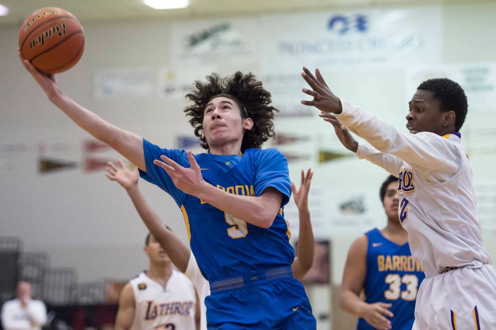 Barrows Brendon Matthews, left, shoots against Lathrops Mekhi Briggman at the Princess Cruises Capital City Classic at Juneau-Douglas High School on Saturday, Dec. 29, 2018. Barrow won 76-68. (Michael Penn | Juneau Empire)