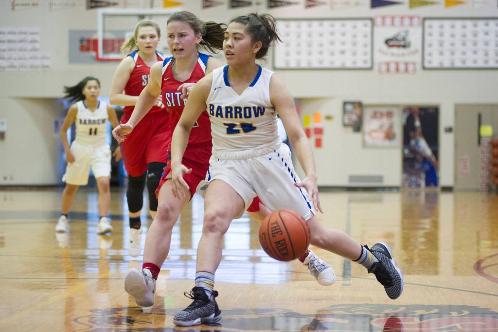 Barrows Jordan Ahgeak, right, drives past Sitkas Tawny Smith at the Princess Cruises Capital City Classic at Juneau-Douglas High School on Saturday, Dec. 29, 2018. Barrow won 58-50. (Nolin Ainsworth | Juneau Empire)