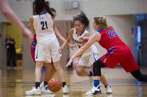 Barrows Lewanne Brower dribbles the ball in between teammate Jenilee Donovan and Sitkas Abby Forrester at the Princess Cruises Capital City Classic at Juneau-Douglas High School on Saturday, Dec. 29, 2018. Barrow won 58-50. (Nolin Ainsworth | Juneau Empire)