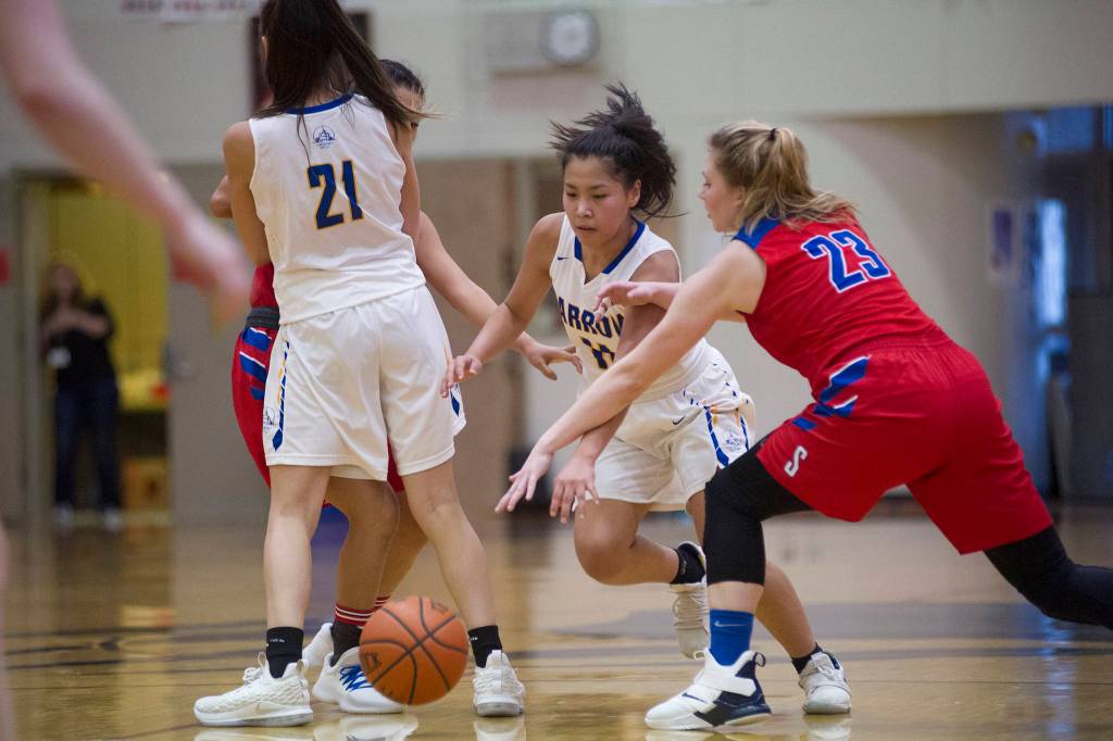 Barrows Lewanne Brower dribbles the ball in between teammate Jenilee Donovan and Sitkas Abby Forrester at the Princess Cruises Capital City Classic at Juneau-Douglas High School on Saturday, Dec. 29, 2018. Barrow won 58-50. (Nolin Ainsworth | Juneau Empire)