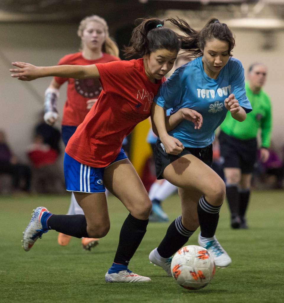 Iced Outs Brianna Jokerst competes against Naughty Lists Blake Plummer in the finals of the high school division at the annual Holiday Cup Soccer Tournament at the Wells Fargo Dimond Park Field House on Monday, Dec. 31, 2018. Iced Out won 8-2. (Michael Penn | Juneau Empire)