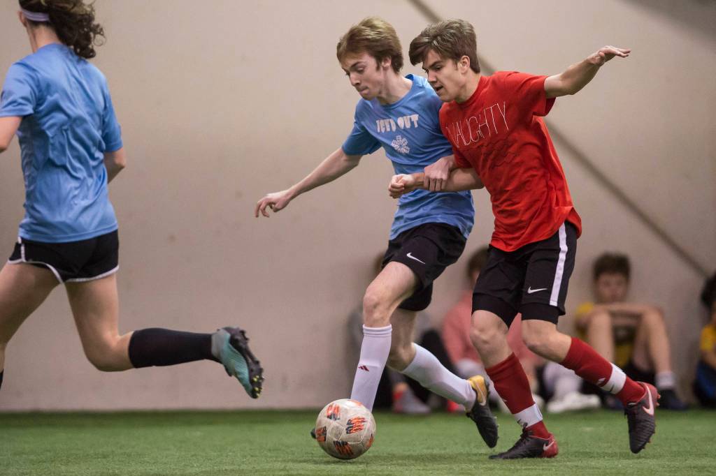 Iced Out, blue, competes against Naughty List, red, in the finals of the high school division at the annual Holiday Cup Soccer Tournament at the Wells Fargo Dimond Park Field House on Monday, Dec. 31, 2018. Iced Out won 8-2. (Michael Penn | Juneau Empire)