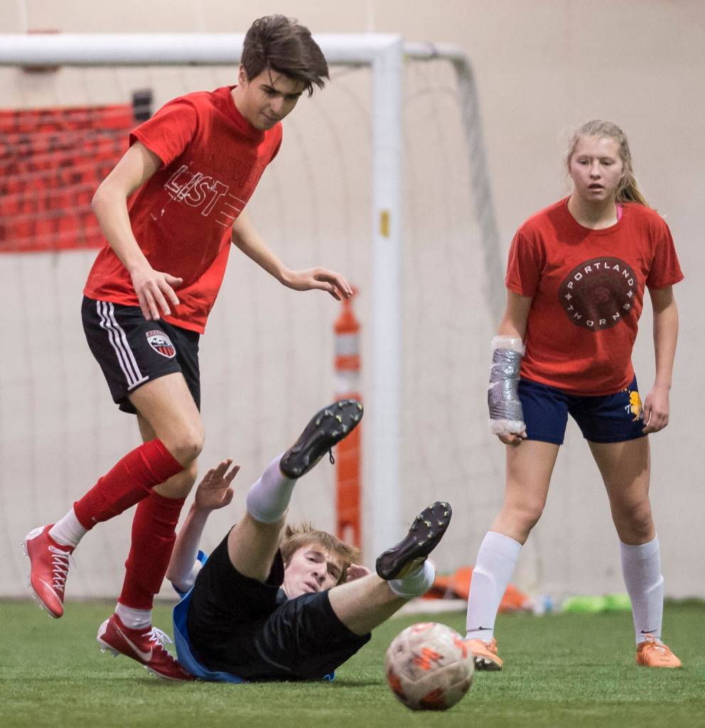 Iced Out, blue, competes against Naughty List, red, in the finals of the high school division at the annual Holiday Cup Soccer Tournament at the Wells Fargo Dimond Park Field House on Monday, Dec. 31, 2018. Iced Out won 8-2. (Michael Penn | Juneau Empire)