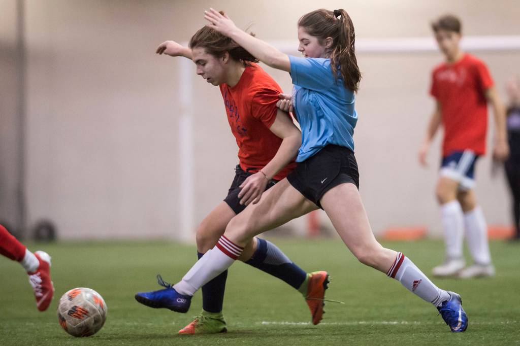Iced Out, blue, competes against Naughty List, red, in the finals of the high school division at the annual Holiday Cup Soccer Tournament at the Wells Fargo Dimond Park Field House on Monday, Dec. 31, 2018. Iced Out won 8-2. (Michael Penn | Juneau Empire)
