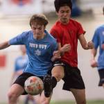 Iced Outs Kanon Goetz, left, battles Naughty Lists Chaehun Yi in the finals of the high school division at the annual Holiday Cup Soccer Tournament at the Wells Fargo Dimond Park Field House on Monday, Dec. 31, 2018. Iced Out won 8-2. (Michael Penn | Juneau Empire)