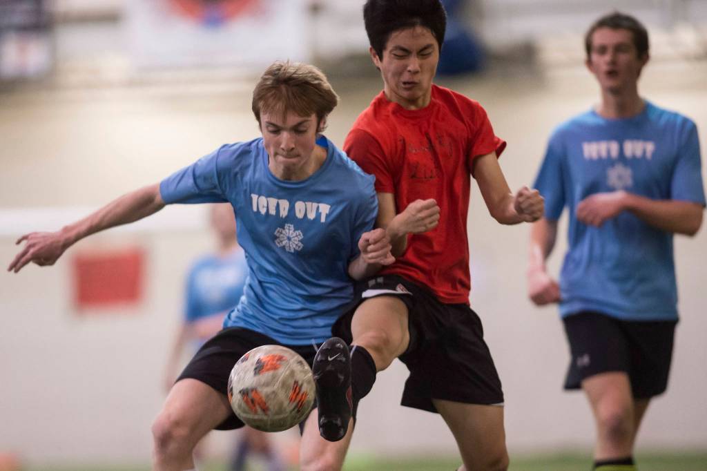 Iced Outs Kanon Goetz, left, battles Naughty Lists Chaehun Yi in the finals of the high school division at the annual Holiday Cup Soccer Tournament at the Wells Fargo Dimond Park Field House on Monday, Dec. 31, 2018. Iced Out won 8-2. (Michael Penn | Juneau Empire)
