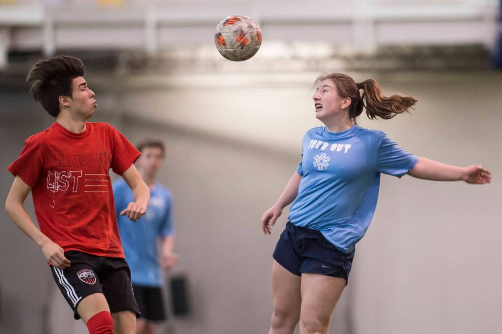 Iced Out, blue, competes against Naughty List, red, in the finals of the high school division at the annual Holiday Cup Soccer Tournament at the Wells Fargo Dimond Park Field House on Monday, Dec. 31, 2018. Iced Out won 8-2. (Michael Penn | Juneau Empire)
