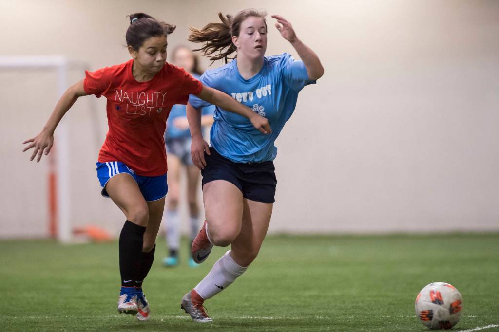 Iced Out, blue, competes against Naughty List, red, in the finals of the high school division at the annual Holiday Cup Soccer Tournament at the Wells Fargo Dimond Park Field House on Monday, Dec. 31, 2018. Iced Out won 8-2. (Michael Penn | Juneau Empire)