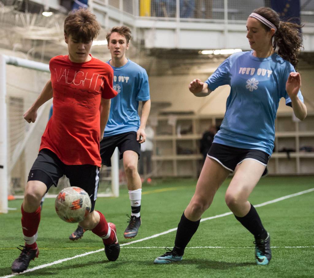 Iced Out, blue, competes against Naughty List, red, in the finals of the high school division at the annual Holiday Cup Soccer Tournament at the Wells Fargo Dimond Park Field House on Monday, Dec. 31, 2018. Iced Out won 8-2. (Michael Penn | Juneau Empire)