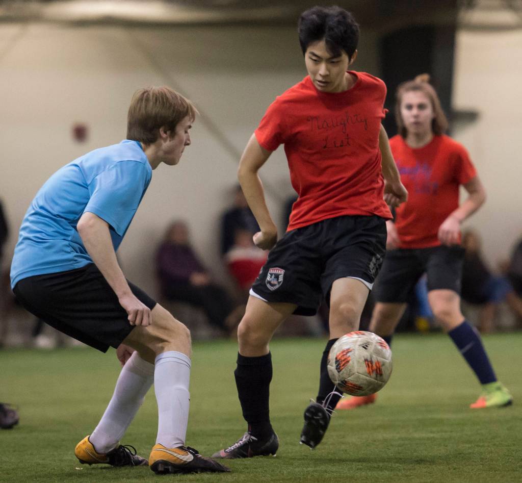 Iced Out, blue, competes against Naughty List, red, in the finals of the high school division at the annual Holiday Cup Soccer Tournament at the Wells Fargo Dimond Park Field House on Monday, Dec. 31, 2018. Iced Out won 8-2. (Michael Penn | Juneau Empire)