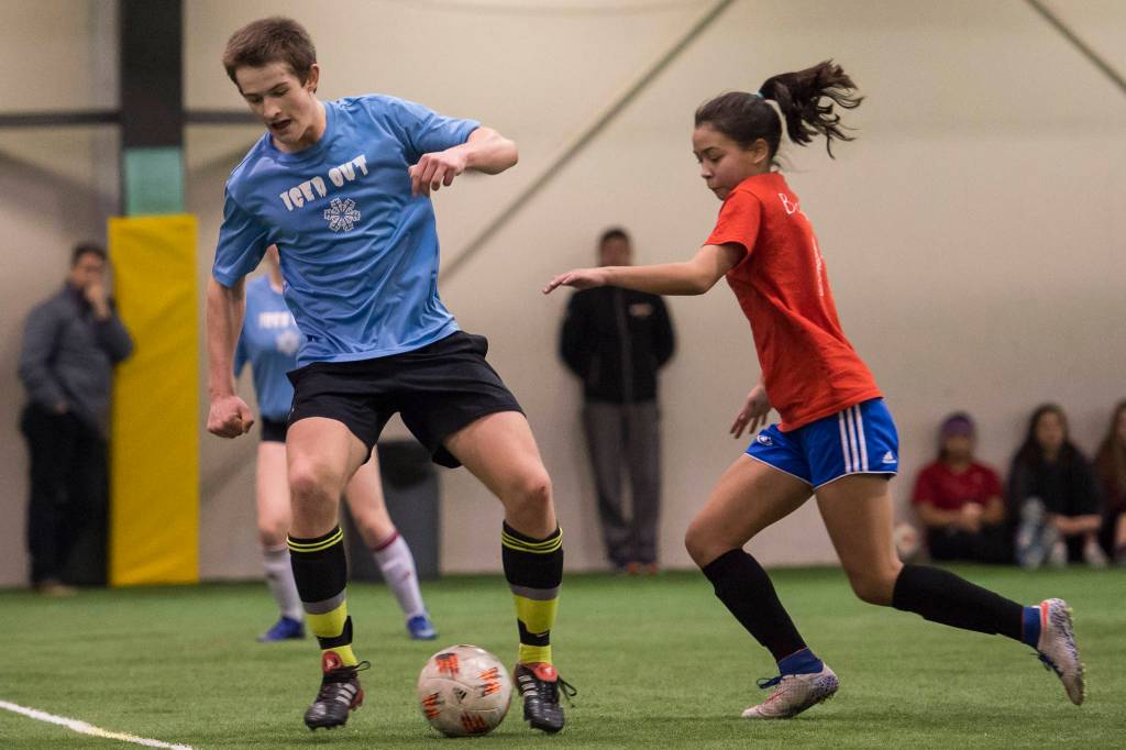 Iced Out, blue, competes against Naughty List, red, in the finals of the high school division at the annual Holiday Cup Soccer Tournament at the Wells Fargo Dimond Park Field House on Monday, Dec. 31, 2018. Iced Out won 8-2. (Michael Penn | Juneau Empire)