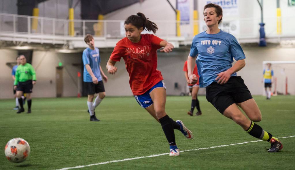 Iced Out, blue, competes against Naughty List, red, in the finals of the high school division at the annual Holiday Cup Soccer Tournament at the Wells Fargo Dimond Park Field House on Monday, Dec. 31, 2018. Iced Out won 8-2. (Michael Penn | Juneau Empire)