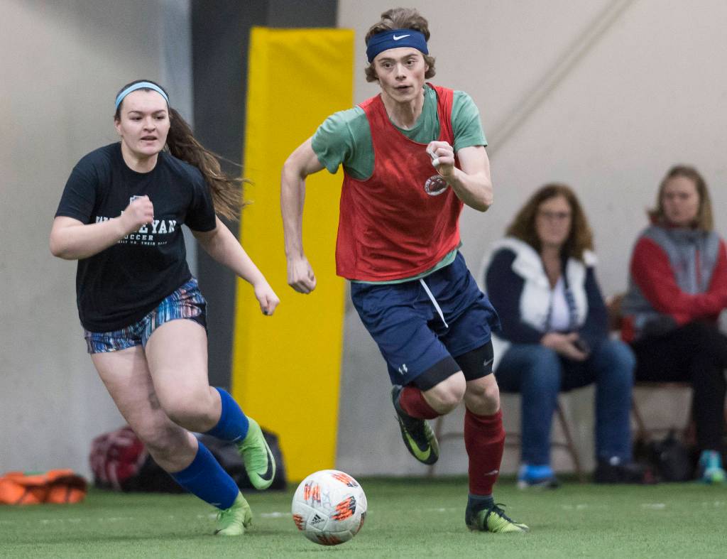 Grinch Gang, red, competes against Black Ice, black, in the finals of the senior division at the annual Holiday Cup Soccer Tournament at the Wells Fargo Dimond Park Field House on Monday, Dec. 31, 2018. The Grinch Gang won 8-2. (Michael Penn | Juneau Empire)