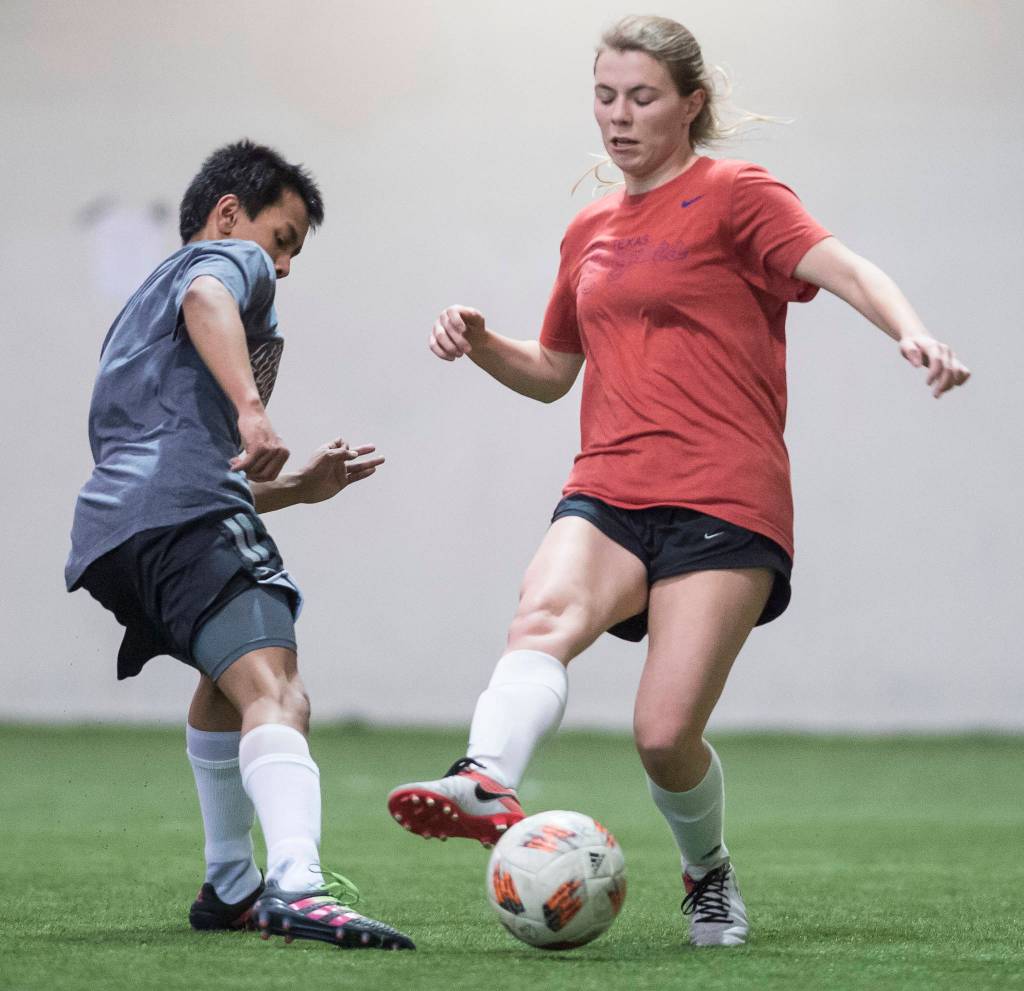 Grinch Gang, red, competes against Black Ice, black, in the finals of the senior division at the annual Holiday Cup Soccer Tournament at the Wells Fargo Dimond Park Field House on Monday, Dec. 31, 2018. The Grinch Gang won 8-2. (Michael Penn | Juneau Empire)