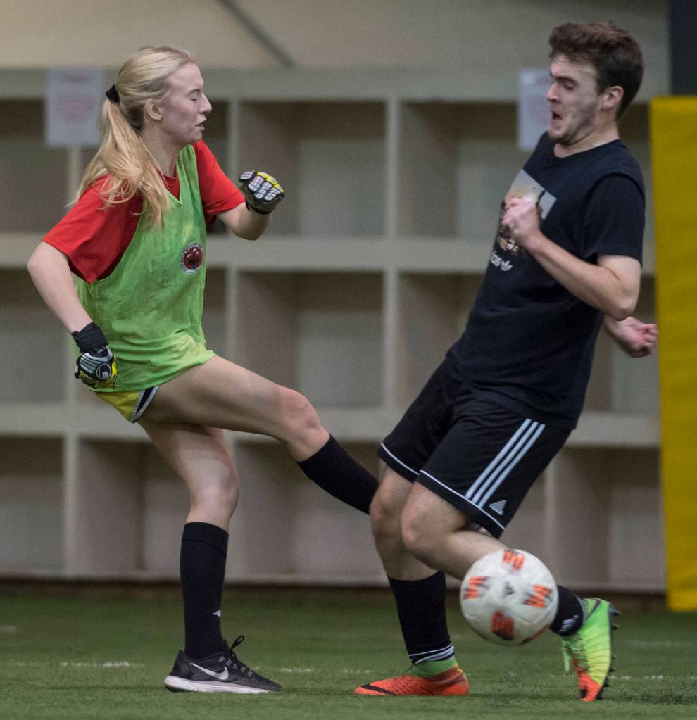 Grinch Gang, red, competes against Black Ice, black, in the finals of the senior division at the annual Holiday Cup Soccer Tournament at the Wells Fargo Dimond Park Field House on Monday, Dec. 31, 2018. The Grinch Gang won 8-2. (Michael Penn | Juneau Empire)