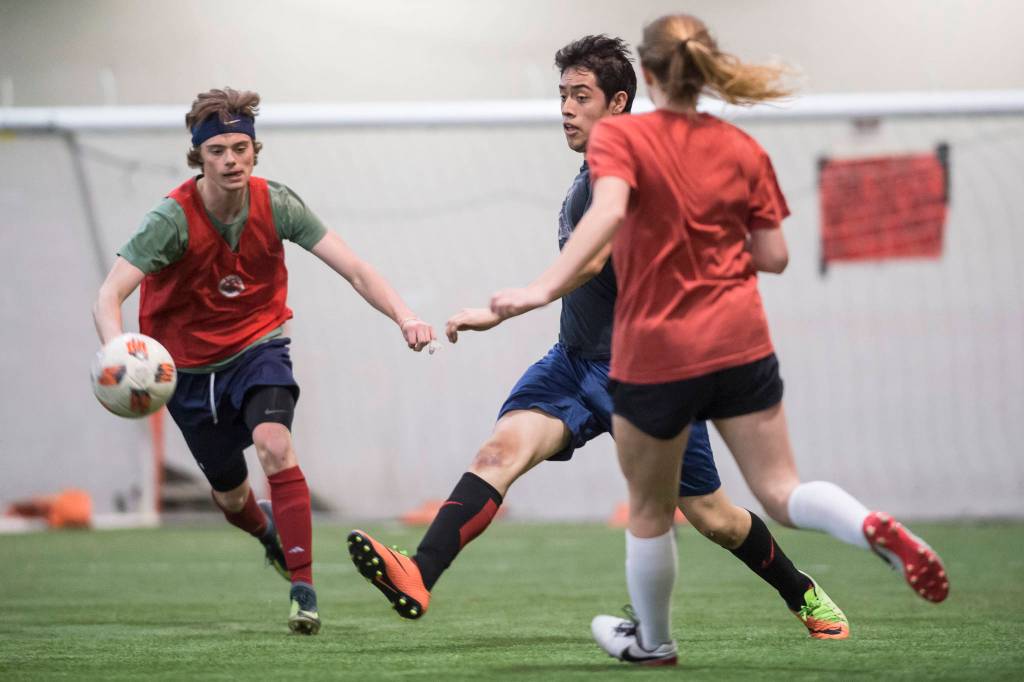 Grinch Gang, red, competes against Black Ice, black, in the finals of the senior division at the annual Holiday Cup Soccer Tournament at the Wells Fargo Dimond Park Field House on Monday, Dec. 31, 2018. The Grinch Gang won 8-2. (Michael Penn | Juneau Empire)