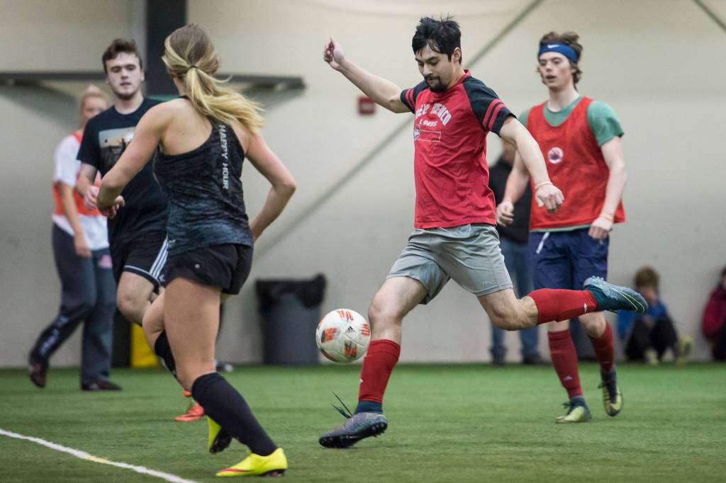 Grinch Gang, red, competes against Black Ice, black, in the finals of the senior division at the annual Holiday Cup Soccer Tournament at the Wells Fargo Dimond Park Field House on Monday, Dec. 31, 2018. The Grinch Gang won 8-2. (Michael Penn | Juneau Empire)