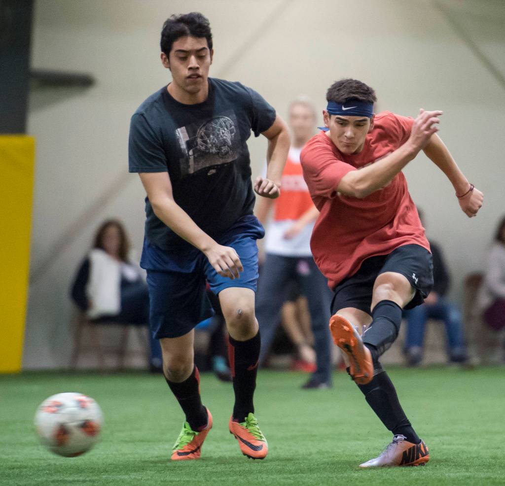 Grinch Gang, red, competes against Black Ice, black, in the finals of the senior division at the annual Holiday Cup Soccer Tournament at the Wells Fargo Dimond Park Field House on Monday, Dec. 31, 2018. The Grinch Gang won 8-2. (Michael Penn | Juneau Empire)