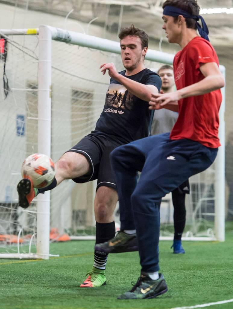 Grinch Gang, red, competes against Black Ice, black, in the finals of the senior division at the annual Holiday Cup Soccer Tournament at the Wells Fargo Dimond Park Field House on Monday, Dec. 31, 2018. The Grinch Gang won 8-2. (Michael Penn | Juneau Empire)
