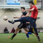 Grinch Gangs Kaleb Tompkins, right, fires a shot to the goal against Black Ices Michael White in the finals of the senior division at the annual Holiday Cup Soccer Tournament at the Wells Fargo Dimond Park Field House on Monday, Dec. 31, 2018. The Grinch Gang won 8-2. (Michael Penn | Juneau Empire)